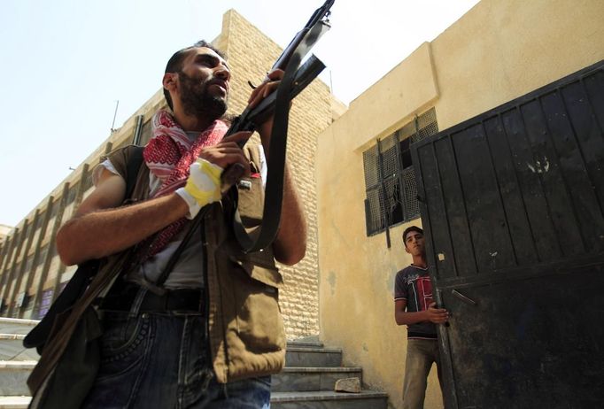 A Free Syrian Army member aims his weapon after hearing shooting in Aleppo July 29, 2012. REUTERS/Zohra Bensemra (SYRIA - Tags: POLITICS CONFLICT CIVIL UNREST MILITARY) Published: Čec. 29, 2012, 3:45 odp.