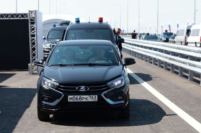 Russian President Vladimir Putin drives a Lada Aura car as he attends a ceremony opening a section of the M-11 "Neva" highway, which connects Moscow and Saint Petersburg,