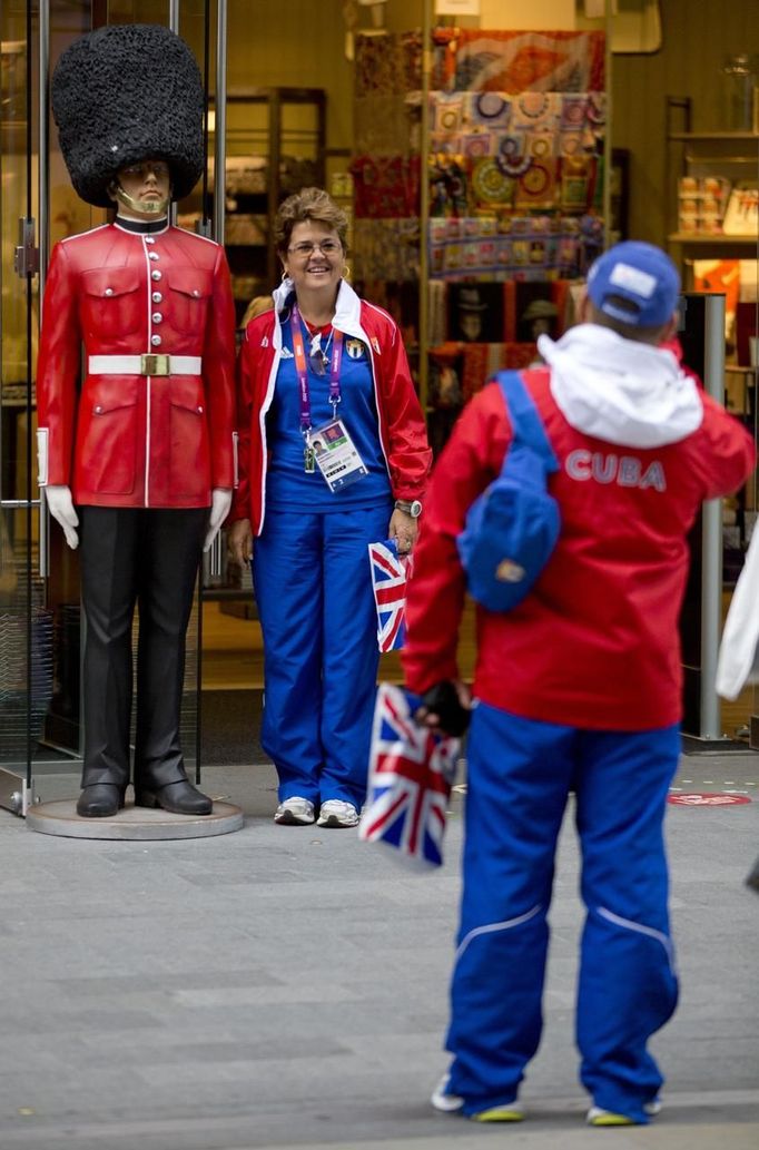 Members of the Cuban Olympic Team pose for photographs in the Westfield Shopping Centre, a major gateway for visitors to the London 2012 Olympic Park, in Stratford, east London, July 19, 2012. REUTERS/Neil Hall (BRITAIN - Tags: SPORT OLYMPICS) Published: Čec. 19, 2012, 1:04 odp.