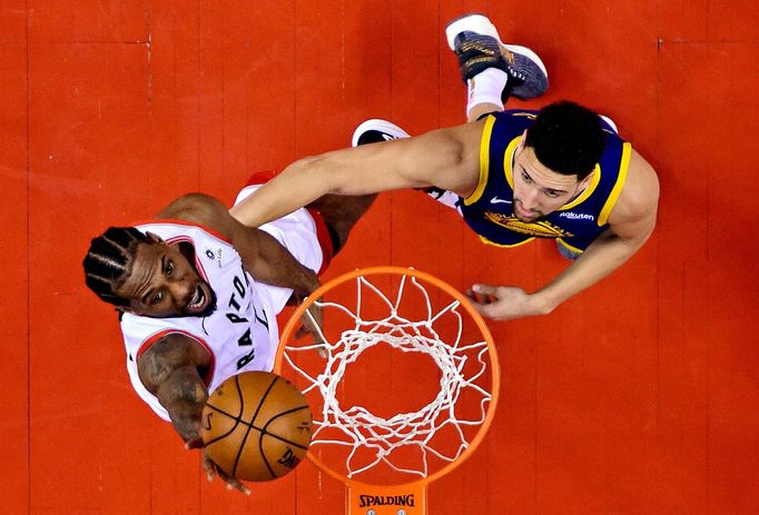 Kawhi Leonard (vlevo) z Toronta skóruje v pátém utkání finále NBA do koše Golden State