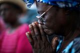 Haitská žena při modlitbě.