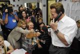Kalifornský guvernér Arnold Schwarzenegger telefonuje během debaty s dobrovolníky, které navštívil během předvolební kampaně.