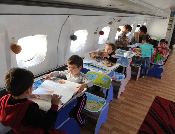 A picture taken on October 29, 2012, shows children playing inside a Soviet-era Yakovlev Yak-42 plane turned into their kindergarten in the Georgian city of Rustavi, some 25 km southeast of the capital Tbilisi. Local head teacher Gari Chapidze bought the old but fully functional Yak-42 from Georgian Airways and refurbished its interior with educational equipment, games and toys but left the cockpit instruments intact so they could be used as play tools.