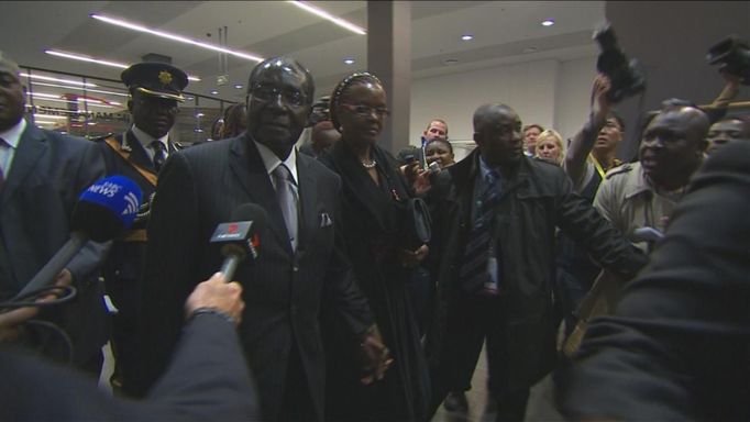 Zimbabwe's President Robert Mugabe (C) and wife Grace arrive in this still image taken from video courtesy of the South Africa Broadcasting Corporation (SABC) at the First National Bank (FNB) Stadium, a