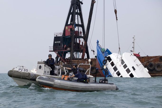 Police boats (L) are seen near a sunken ferry being lifted out of the water after an accident off Hong Kong October 2, 2012. At least 36 people died and dozens were injured when the ferry carrying more than 120 people on a company outing collided with another ferry and sank near an island south of Hong Kong on Monday night in one of the city's worst maritime accidents. REUTERS/Tyrone Siu (CHINA - Tags: DISASTER TRANSPORT) Published: Říj. 2, 2012, 3:03 dop.