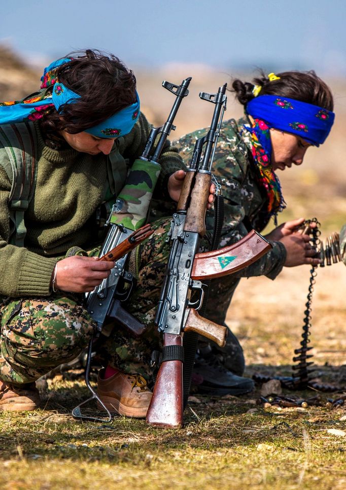 Female fighters of the Kurdish People's Protection Units (YPG) prepare their weapons as they participate in a military training in the western countryside of Ras al-Ain