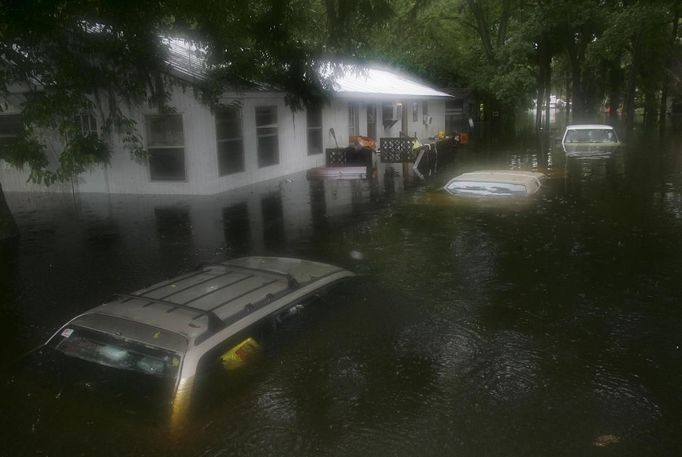 RNPS IMAGES OF THE YEAR 2012 - Three submerged cars sit in front of a flooded trailer in Live Oak, Florida, June 26, 2012. Tropical Storm Debby drifted slowly eastward over Florida's Gulf Coast on Tuesday, threatening to dump more rain on areas already beset by flooding. After stalling in the Gulf of Mexico, the storm was finally moving but was expected to take two more days to finish its wet slog across Florida. Picture taken June 26, 2012. EDITORS NOTE: Moisture on the lens. REUTERS/Phil Sears (UNITED STATES - Tags: ENVIRONMENT DISASTER TPX IMAGES OF THE DAY) Published: Pro. 5, 2012, 11:15 odp.