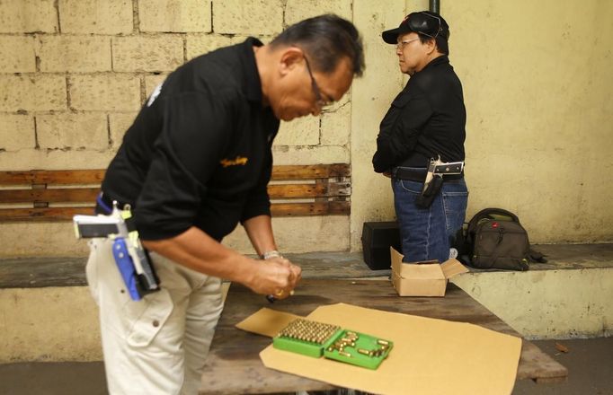 Jaime "Jimmy" Santiago (L), a lower court judge in Manila, loads bullets before a shooting practice with fellow court judges at a police firing range in Manila March 6, 2013. Santiago, a former police officer who headed a special weapons and tactics (SWAT) unit, favours arming Filipino judges to protect themselves from disgruntled litigants who can't accept decisions and criminal syndicates whose members were sent to jail. There had been cases of shootings inside courtrooms. At right is lower court judge Armando Yanga. REUTERS/Romeo Ranoco (PHILIPPINES - Tags: POLITICS CRIME LAW) Published: Dub. 4, 2013, 11:03 dop.