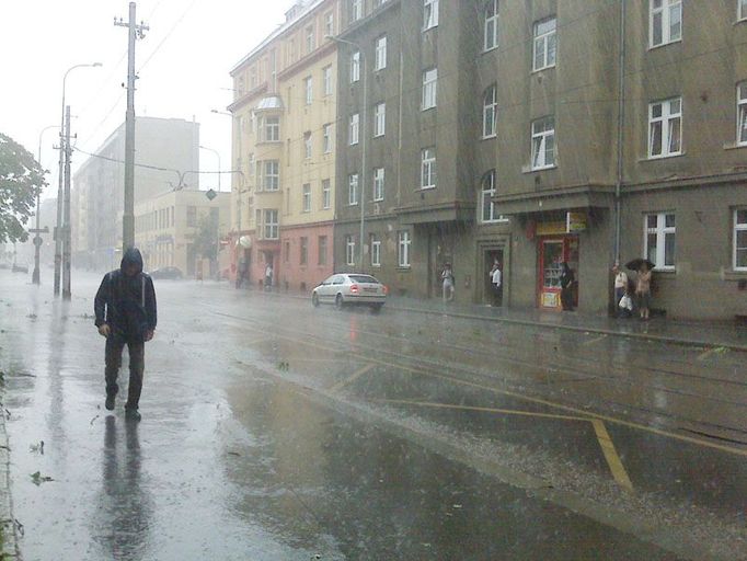 Prudký déšť zanechal na ulicích sloupec vody, který nestíhal odtéce. Praha, 23. července po páté hodině večerní.