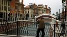 A man smokes a cigarette as he stands on a bridge over a canal that flows through the center of the Florentia Village in the district of Wuqing, located on the outskirts of the city of Tianjin June 13, 2012. The shopping center, which covers an area of some 200,000 square meters, was constructed on a former corn field at an estimated cost of US$220 million and copies old Italian-style architecture with Florentine arcades, a grand canal, bridges, and a building that resembles a Roman Coliseum. REUTERS/David Gray (CHINA - Tags: SOCIETY BUSINESS) Published: Čer. 13, 2012, 5:50 odp.