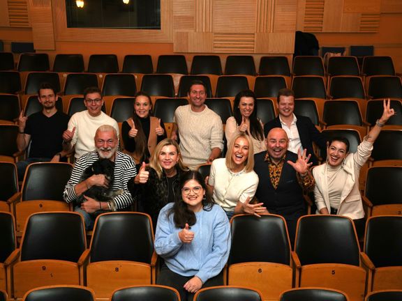 Studentka Maruška Švárová, za níž sedí zpěváci a zpěvačky, kteří budou zpívat 3. prosince 2025 na dobročinném koncertu Muzikálem bez bariér. Ten pomůže právě Marušce.