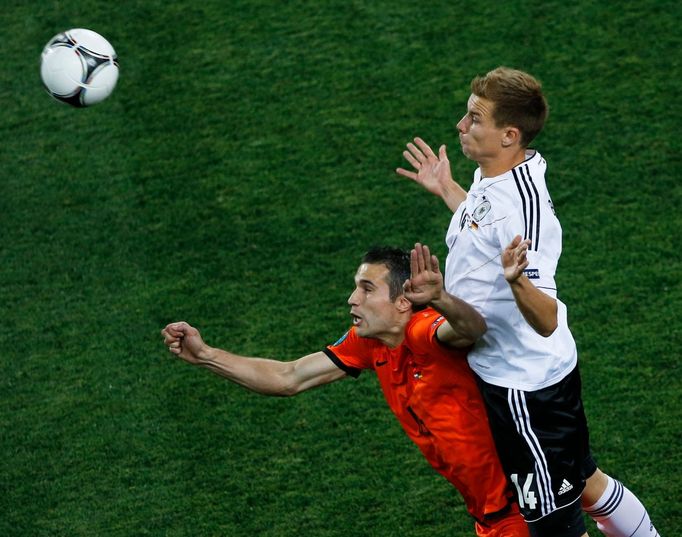 Robin van Persie a Holger Badstuber bojují o míč během utkání Nizozemska s Německem ve skupině B na Euru 2012.