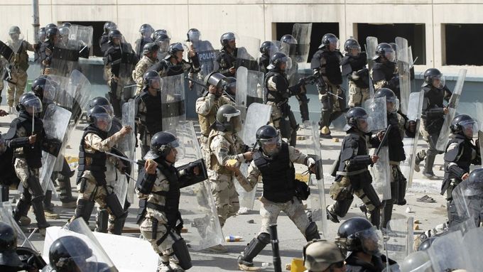 Iráčtí policisté se brání před demonstranty házejícími kamení