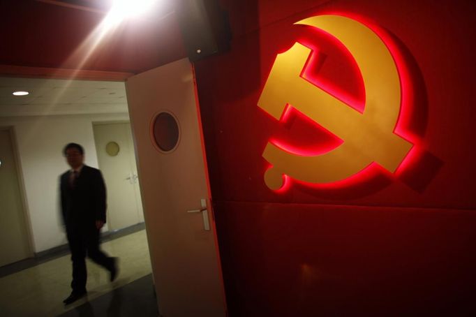 A trainee walks pass a communist party logo as he attends a training course at the communist party school called China Executive Leadership Academy of Pudong in Shanghai, in this September 24, 2012 file photo. With China's economy slowing and public scrutiny of officials on the rise via social media, the party is likely to endorse deepening its training push when Hu passes the baton to new leaders at the 18th Party Congress, which is expected to be held as early as next month. China's cadre training system is run out of academies across the country, some focusing on practical aspects of 21st century communism such as handling the media and management skills, including role-play scenarios on how to manage a variety of crises from mass protests to train crashes. Picture taken September 24, 2012. REUTERS/Carlos Barria/Files (CHINA - Tags: POLITICS SOCIETY BUSINESS LOGO) Published: Zář. 25, 2012, 9 odp.