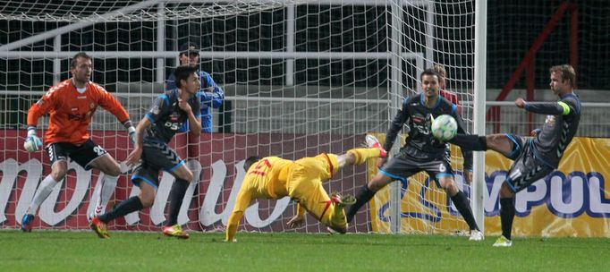 Fotbalista Dukly Praha Lukáš Štětina střílí proti Ondřeji Šourkovi a sleduje to i Jaromír Blažek z Vysočiny Jihlava v utkání Gambrinus ligy 2012/13.