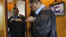 Jaime "Jimmy" Santiago, a lower court judge in Manila, puts on his robe before attending the hearing of a case at his sala at the Regional Trial Court branch 3 at city hall in Manila March 5, 2013. Santiago, a former police officer who headed a special weapons and tactics (SWAT) unit, favours arming Filipino judges to protect themselves from disgruntled litigants who can't accept decisions and criminal syndicates whose members were sent to jail. There had been cases of shootings inside courtrooms. REUTERS/Romeo Ranoco (PHILIPPINES - Tags: POLITICS CRIME LAW) Published: Dub. 4, 2013, 10:54 dop.