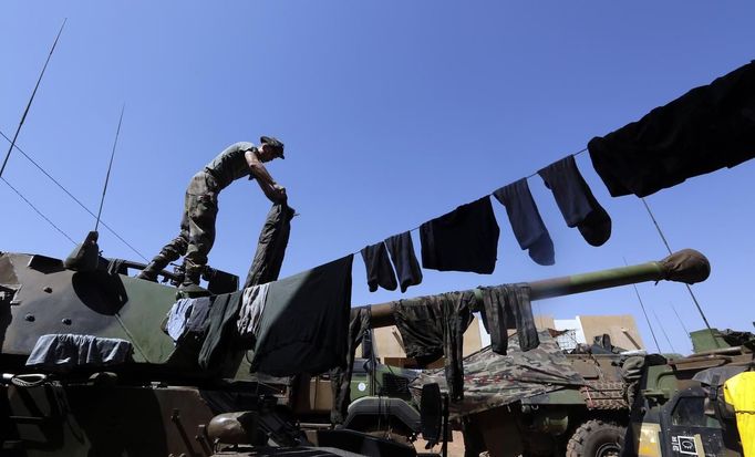 A French soldier hangs his clothes to dry on an armoured vehicle at the Mali air force base near Bamako as troops await their deployment January 18, 2013. REUTERS/Eric Gaillard (MALI - Tags: CIVIL UNREST CONFLICT MILITARY) Published: Led. 18, 2013, 5:30 odp.