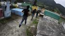 People run through a cemetery as the police rescues four men accused of theft in Tactic, in Alta Verapaz region, about 189km (117 miles) from Guatemala City, September 13, 2012. The local community tied up and beat four men who were accused of theft in the aftermath of a school killing, which had occurred on Wednesday. The man, who had entered a classroom and killed two children, ages 8 and 13, with a machete, was lynched and burnt alive by a mob, local media reported. REUTERS/Jorge Dan Lopez (GUATEMALA - Tags: CRIME LAW SOCIETY) Published: Zář. 13, 2012, 6:09 odp.