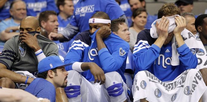 Vince Carter, Brendan Haywood a Dirk Nowitzki. Lavička Dallasu zklamaná z toho, že obhájce titulu končí v ply ff NBA po porážce 0:4 v sérii s Oklahomou