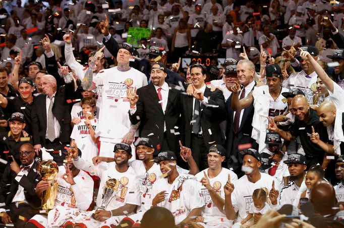 The Miami Heat players, coaches, owner and other staff pose with the Larry O'Brien Championship Trophy (lower L) after their team defeated the San Antonio Spurs in Game 7