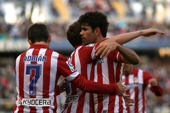 Atletico Madrid's Koke is congratulated by his teammates Costa and Adrian after scoring a goal against Malaga during their Spanish First Division soccer match in Malaga