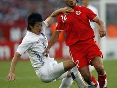 Korejec Kim Nam-il (v bílém )se snaží přpravit o míč Hakana Yakina ze Švýcarska.