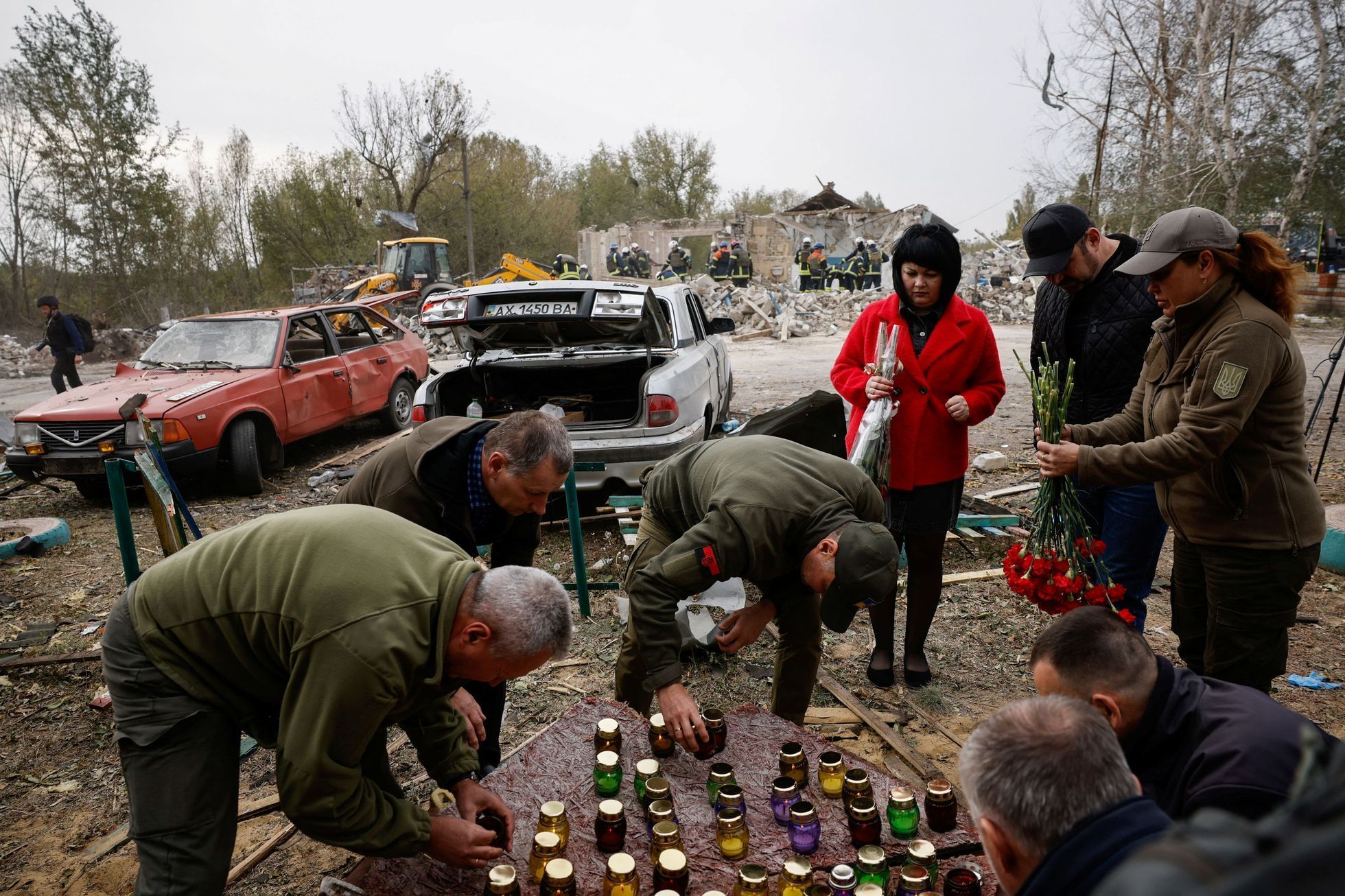 Lidé nosí svíčky a květiny na místo, kde po dopadu ruské rakety Iskander zemřelo ve čtvrtek ve vesnici Hroza 52 lidí.