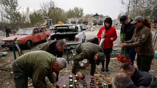 Lidé nosí svíčky a květiny na místo, kde po dopadu ruské rakety Iskander zemřelo ve čtvrtek ve vesnici Hroza 52 lidí.