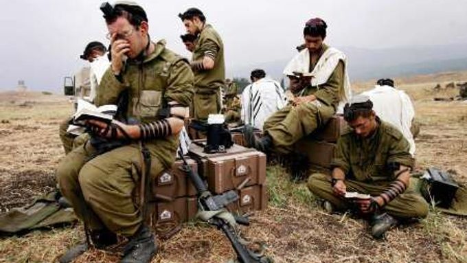Příslušníci izraelského dělostřelectva, kteří ostřelují jih Libanonu, se modlí na svém stanovišti.