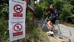 cedule "africký mor prasat zákaz vstupu se psy", cyklista, kolo