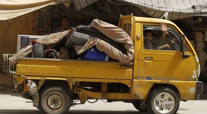 A man waves as he flees Aleppo July 29, 2012. REUTERS/Zohra Bensemra (SYRIA - Tags: CIVIL UNREST MILITARY POLITICS CONFLICT) Published: Čec. 29, 2012, 4:50 odp.