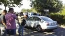 People stand at a car park after an explosion at Bulgaria's Burgas airport July 18, 2012. At least four people were killed and over 20 injured by an explosion on a bus carrying Israeli tourists outside the airport of the coastal city of Burgas on Wednesday, Bulgarian authorities said. The mayor of the city, on Bulgaria's Black Sea coast, said the bus was carrying Israeli tourists, but police could not immediately confirm their nationality. Police said several other buses at the site had been damaged. REUTERS/Impact Press Group (BULGARIA - Tags: DISASTER TRANSPORT)