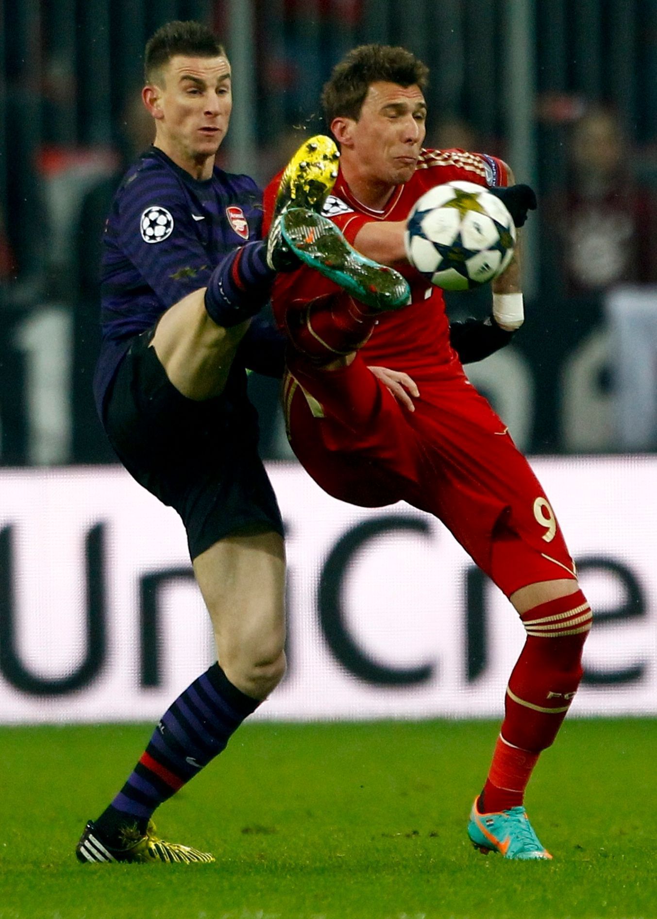 Fotbal, Liga mistrů, Bayern Mnichov - Arsenal: Mario Mandzukič (vpravo) - Laurent Koscielny