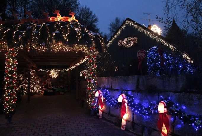 A house decorated with Christmas lights and figurines is lit up in Freising, about 30 km (18.6 miles) north of Munich December 1, 2012. Each year, several home owners set up fairy lights for the year-end holidays. For this particular home, Ulla and Hilmar Haubrich used more than 20,000 lights and 300 empty gift boxes. Picture taken December 1, 2012. REUTERS/Michaela Rehle (GERMANY - Tags: SOCIETY ANNIVERSARY) Published: Pro. 2, 2012, 11:44 dop.