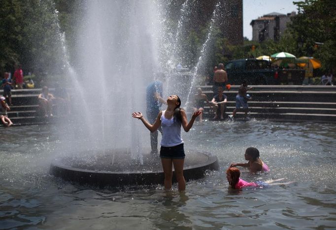 People play in the fountain at Washington Square Park in New York July 1, 2012. Blistering heat blanketed much of the eastern United States for the third straight day on Sunday, after violent storms that took at least a dozen lives and knocked out power to more than 3 million customers. REUTERS/Eric Thayer (UNITED STATES - Tags: ENVIRONMENT SOCIETY) Published: Čec. 1, 2012, 8:44 odp.