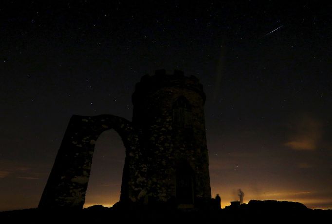 A meteor streaks across the sky during the Perseid meteor shower at Bradgate Park in Newtown Linford