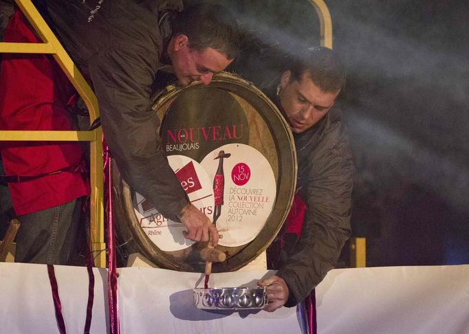 Men tap wine from a barrel during the official launch of the 2012 Beaujolais Nouveau wine in the center of Lyon early November 15, 2012. REUTERS/Robert Pratta (FRANCE - Tags: SOCIETY) Published: Lis. 15, 2012, 2:20 dop.