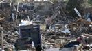 People walk through their tornado-ravaged neighbourhood in Moore, Oklahoma May 21, 2013. Rescuers went building to building in search of victims and thousands of survivors were homeless on Tuesday after a massive tornado tore through the Oklahoma City suburb of Moore, wiping out whole blocks of homes and killing at least 24 people. REUTERS/Rick Wilking (UNITED STATES - Tags: DISASTER ENVIRONMENT) Published: Kvě. 22, 2013, 1:29 dop.