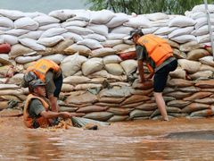 Čínská osvobozenecká armáda umisťuje pytle naplněné pískem a kameny ke břehům řek.