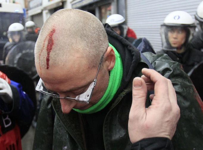 A man bleeds on his head during riots between policemen and Arcelor Mittal workers from several Liege steel plants demonstrating outside the Walloon Region parliament in Namur January 29, 2013. ArcelorMittal, the world's largest steel producer, plans to shut a coke plant and six finishing lines at its site in Liege, Belgium, affecting 1,300 employees, the group said last week. REUTERS/Yves Herman (BELGIUM - Tags: CIVIL UNREST BUSINESS EMPLOYMENT COMMODITIES) Published: Led. 29, 2013, 2:08 odp.