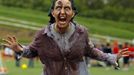 A zombie greets runners arriving for the "Run for Your Lives" 5K obstacle course race in Amesbury, Massachusetts May 5, 2012. Runners face man-made and natural obstacles on the course, while being chased by zombies, who try to take "health" flags off the runners belts. REUTERS/Brian Snyder (UNITED STATES - Tags: SPORT SOCIETY) Published: Kvě. 5, 2012, 8:15 odp.