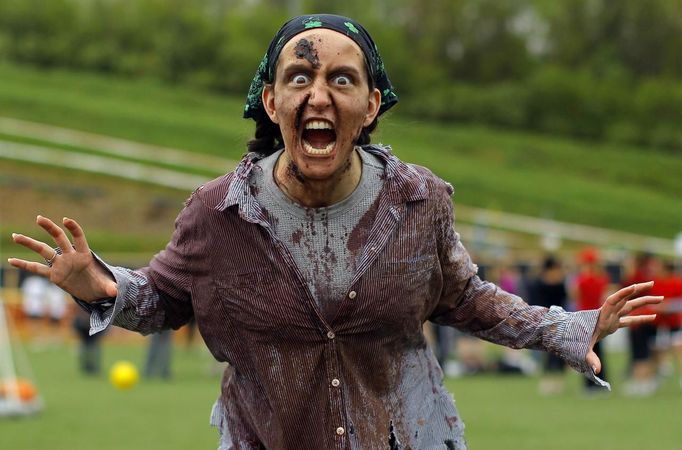 A zombie greets runners arriving for the "Run for Your Lives" 5K obstacle course race in Amesbury, Massachusetts May 5, 2012. Runners face man-made and natural obstacles on the course, while being chased by zombies, who try to take "health" flags off the runners belts. REUTERS/Brian Snyder (UNITED STATES - Tags: SPORT SOCIETY) Published: Kvě. 5, 2012, 8:15 odp.