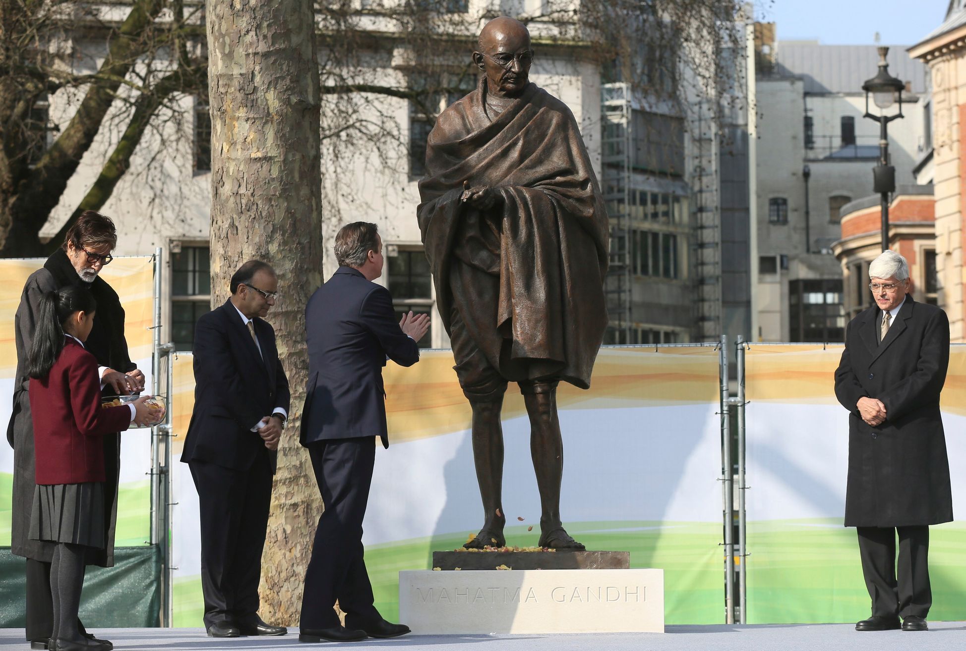 Indian actor Amitabh Bachchan , Indian finance minister Shri Arun Jaitley ,Ghandi's grandson Gopalkrishna Gandhi look on as Britain's Prime Minister David Cameron gestures towards a statue of  Mahatma