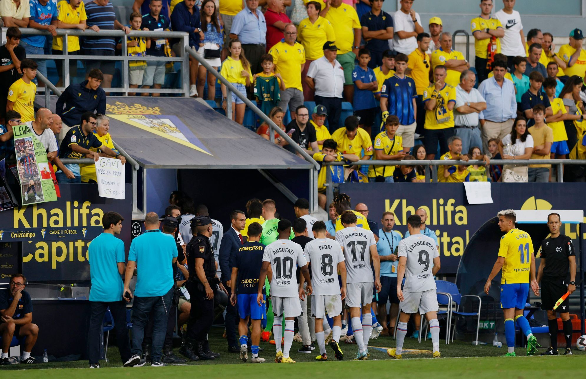 Hráči Cádiz a Barcelony během přestávky, během níž byl v hledišti oživování fanoušek