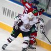 Hokejista Vitalij Karamnov (vzadu) chrání puk před Mattem Carlem v utkání KHL 2012/13 mezi Lvem Praha s Dinamem Riga .