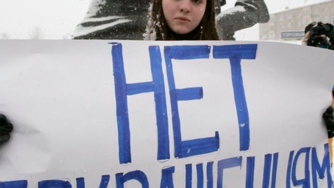 Moskva už má za sebou několik protestů proti finanční krizi, respektive vlažnému přístupu vlády k řešení. Demonstrantka drží plakát s nápisem "Ne škrtům".