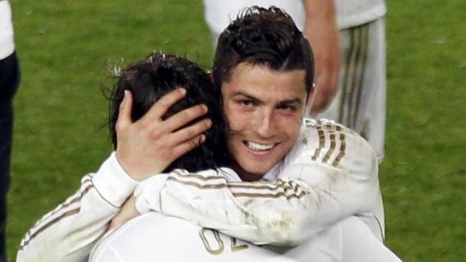 Cristiano Ronaldo objímá Özila poté, co dal Real Seville branku