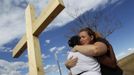 Naomi Hicks (R) hugs a woman at a memorial for victims, behind the theater where a gunman opened fire on moviegoers in Aurora, Colorado July 21, 2012. James Holmes, the suspect accused of a shooting rampage at a Denver- area premiere of the new "Batman" film, received a high volume of deliveries at work and home over the past four months, police said, parcels they believe contained ammunition and possibly bomb-making materials. REUTERS/Shannon Stapleton (UNITED STATES - Tags: CRIME LAW SOCIETY CIVIL UNREST OBITUARY TPX IMAGES OF THE DAY) Published: Čec. 22, 2012, 12:31 dop.