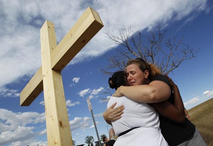 Naomi Hicks (R) hugs a woman at a memorial for victims, behind the theater where a gunman opened fire on moviegoers in Aurora, Colorado July 21, 2012. James Holmes, the suspect accused of a shooting rampage at a Denver- area premiere of the new "Batman" film, received a high volume of deliveries at work and home over the past four months, police said, parcels they believe contained ammunition and possibly bomb-making materials. REUTERS/Shannon Stapleton (UNITED STATES - Tags: CRIME LAW SOCIETY CIVIL UNREST OBITUARY TPX IMAGES OF THE DAY) Published: Čec. 22, 2012, 12:31 dop.