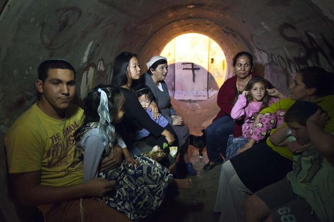 Israelis sit inside a sewage pipe used as shelter during alert, warning of incoming rockets, in the southern community of Nitzan, near Ashdod November 15, 2012. A Hamas rocket killed three Israelis north of the Gaza Strip on Thursday, drawing the first blood from Israel as the Palestinian death toll rose to 15 in a military showdown lurching closer to all-out war and an invasion of the enclave. REUTERS/Nir Elias (ISRAEL - Tags: POLITICS CIVIL UNREST) Published: Lis. 15, 2012, 4:43 odp.